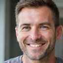 Smiling man, late 40s, looking fit and energetic after a health transformation.